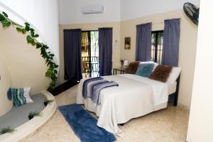 a bedroom with a white bed and blue rugs at Refugio Encantador in Santo Domingo