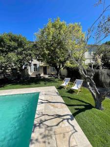 un patio con 2 sillas y una piscina en Aubignan's Convent - Character house & pool, en Aubignan