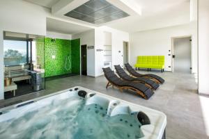 a large bathroom with a tub with chairs in it at Villa Rita Pool & Spa in Mascalucia