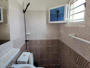 a bathroom with a toilet and a window at Mawolè in Cotonou