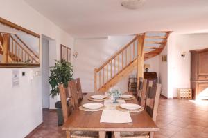 uma sala de jantar com uma mesa de madeira e escadas de madeira em Vila Lipno em Frymburk