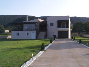 a large white house with a driveway at Thalpo home in Ioannina