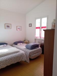 2 camas en una habitación con 2 ventanas en Poggio agli Ulivi, en Frascati