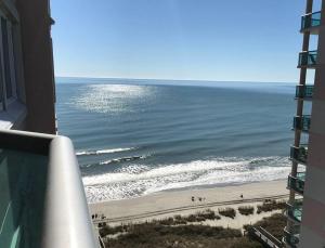 ein Blick auf den Strand vom Balkon eines Gebäudes in der Unterkunft Oceanfront Get Away in Myrtle Beach