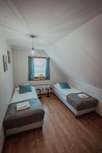 a bedroom with two beds and a window at Gościniec Chlebowy Zakątek 