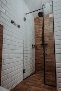 y baño con ducha y puerta de cristal. en Gościniec Chlebowy Zakątek, 