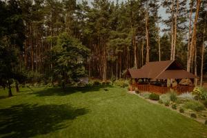 un cenador en medio de un patio con árboles en Gościniec Chlebowy Zakątek, 