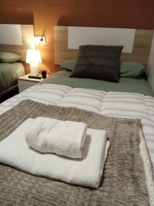 a large bed with a white towel on it at Hotel Rural Mirador de Solana in Solana de ávila