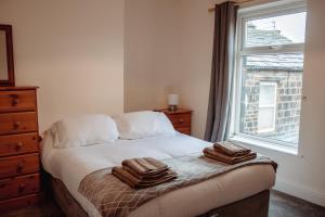 a bedroom with a bed with two towels on it at Rustic Cottage in Heart of Town in Otley