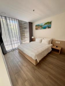 a bedroom with a large bed and a large window at Villa biển Oceanami B805 - Ô tô đậu trước cửa nhà in Long Hai