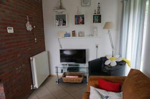 ein Wohnzimmer mit einem Sofa und einem TV in der Unterkunft Kustverhuur Park Schoneveld Zeester 66 in Breskens