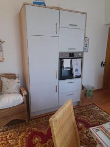 a large white cabinet in a room with a chair at Kurpension Parkfrieden in Bad Pyrmont