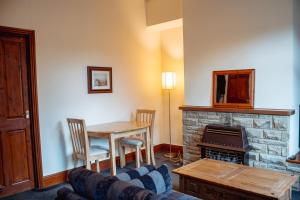 ein Wohnzimmer mit einem Tisch und einem Kamin in der Unterkunft Rustic Cottage in Heart of Town in Otley