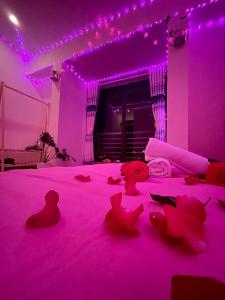 Cette chambre violette comprend un lit avec un éclairage rose. dans l'établissement House Thị Đà Lạt, à Đà Lạt