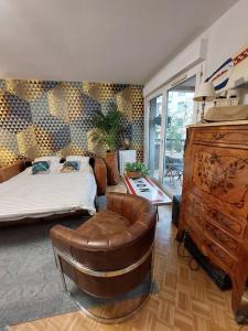 - une chambre avec un lit, une chaise et une commode dans l'établissement Le Cosy-chic - T3 Balneo à Villeurbanne / Lyon, à Villeurbanne