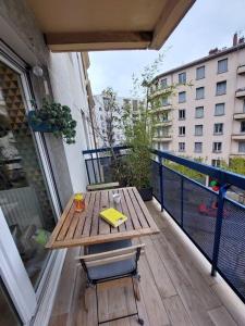 d'une table et de chaises en bois sur un balcon. dans l'établissement Le Cosy-chic - T3 Balneo à Villeurbanne / Lyon, à Villeurbanne