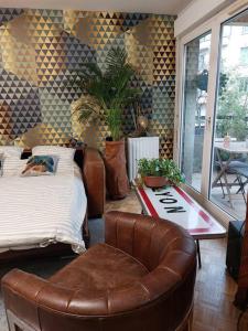 - un salon avec un lit et un fauteuil en cuir dans l'établissement Le Cosy-chic - T3 Balneo à Villeurbanne / Lyon, à Villeurbanne