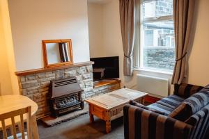 a living room with a couch and a fireplace at Rustic Cottage in Heart of Town in Otley