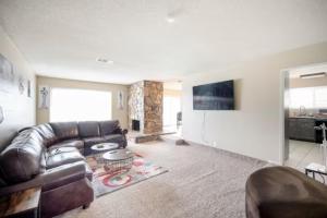 a living room with a leather couch and a tv at Pool 4 bedroom 2 bath close to Strip in Las Vegas