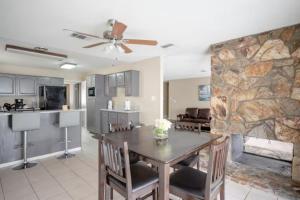 a kitchen and living room with a table and a stone wall at Pool 4 bedroom 2 bath close to Strip in Las Vegas