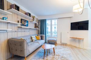 a living room with a couch and a table at Luxueux Appartement Design 70m2 Disneyland Paris pour 6pax in Chessy