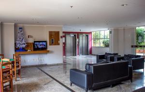 a living room with black furniture and a christmas tree at Temporada Thermas Place Suítes Caldas Novas in Caldas Novas