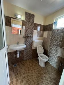 a bathroom with a toilet and a sink at Little Pilgrim Family Lodge in Pokhara