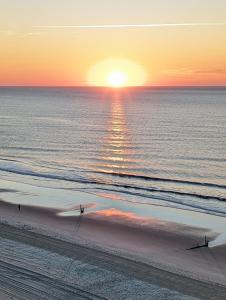 people walking on the beach at the sunset at Oceanfront Get Away in Myrtle Beach
