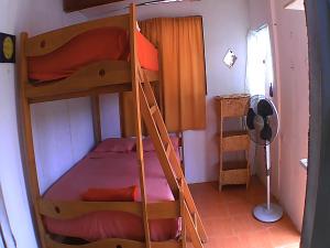 - une chambre avec 2 lits superposés et une échelle dans l'établissement Wiracocha Hostal Máncora - Surf Camp, à Máncora