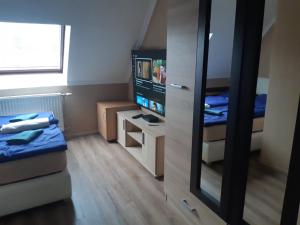 ein kleines Zimmer mit einem Bett und einem Spiegel in der Unterkunft Bajnok Apartman in Hévíz