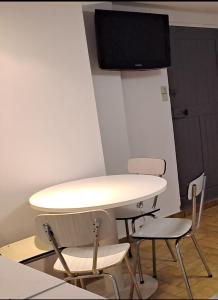 un tavolo bianco con sedie in una camera con TV di Maison saba a Sevran