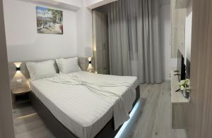 1 dormitorio con 1 cama con sábanas blancas en CELINE CONFORT N. D. COCEA en Bucarest