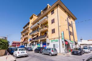 un edificio alto con coches estacionados frente a él en Casa vacanza Luna, en Cassibile