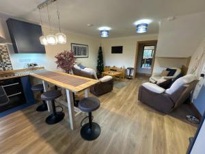 een keuken en een woonkamer met een tafel en stoelen bij New city flat, 3 x double bed en-suite bedrooms, private kitchen & lounge, free private parking & own workspaces in Exeter