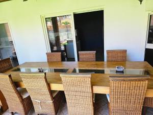 VILLA VALIHA في Koungou: طاولة طعام مع كراسي وطاولة خشبية