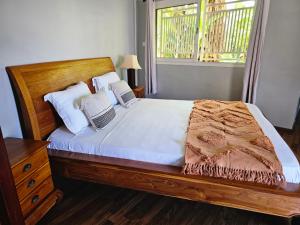 VILLA VALIHA في Koungou: غرفة نوم بسرير وملاءات بيضاء ونافذة
