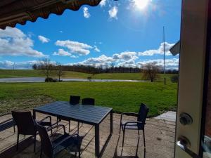 una mesa y sillas en un patio con vistas a un campo en Annex88 B&B en Fårvang