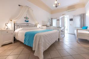 a bedroom with a bed and a table and a chair at Reverie Santorini Hotel in Firostefani