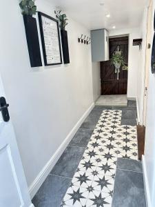 a hallway with a black and white tile floor at Cosy Stylish Studio Apartment in Trowbridge
