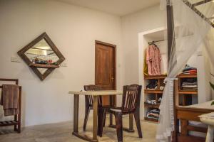 a dining room with a table and chairs and a mirror at Lawrence Villa in Weligama