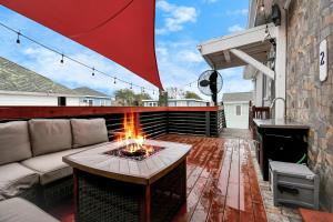 a patio with a couch and a fire pit at Nautical Loft with Outdoor Kitchen & Beach Access in Galveston