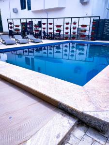 a swimming pool with chairs in a building at ADDRESS HOTELS AND TOWERS MAITAMA in Abuja