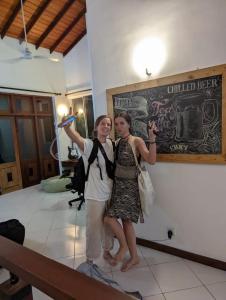 two women standing in a room with their hands in the air at Culture Hub Backpack Hostel in Sri Jayewardenepura Kotte