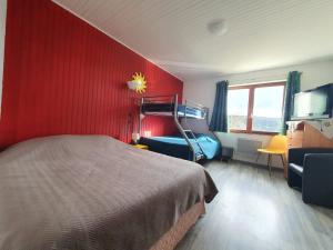 ein Schlafzimmer mit einer roten Wand mit einem Bett und einem Stuhl in der Unterkunft Domaine L'Impératrice in Plombières-les-Bains