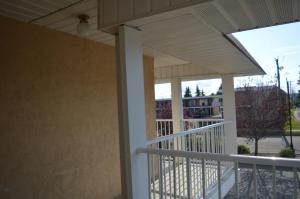 - une terrasse couverte avec un auvent et une vue sur un bâtiment dans l'établissement Circle 5 Motel, à Olds
