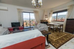sypialnia z łóżkiem, telewizorem i stołem w obiekcie Κατοικία Αυγερινού w mieście Amfikleia