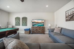 a living room with a couch and a pool table at 85| Southern Comfort in St George with Hot Tub in Santa Clara