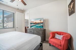 a bedroom with a bed and a red chair at 85| Southern Comfort in St George with Hot Tub in Santa Clara +43 photos