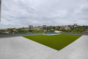 an open patio with a green lawn and buildings at 707 at 2SIX2 Florida Road by HostAgents in Durban