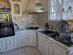 a kitchen with white cabinets and a sink at La maison du Pêcheur in Terre-de-Haut +2 photos